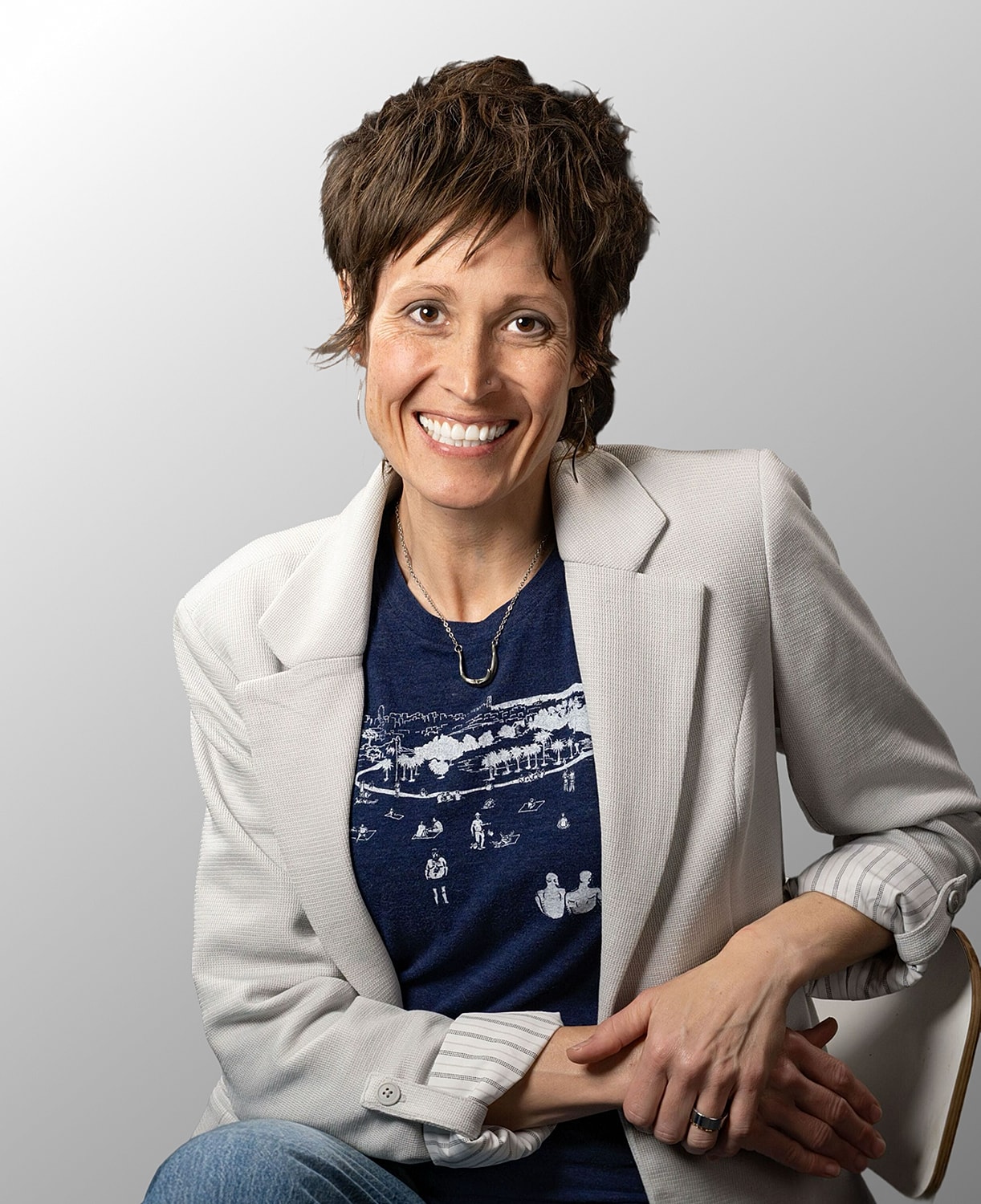 Smiling woman in casual outfit, gray background.