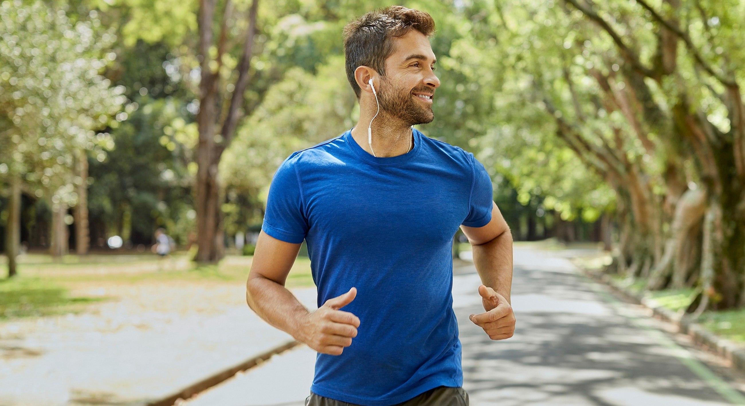 Man jogging outdoors with headphones on.