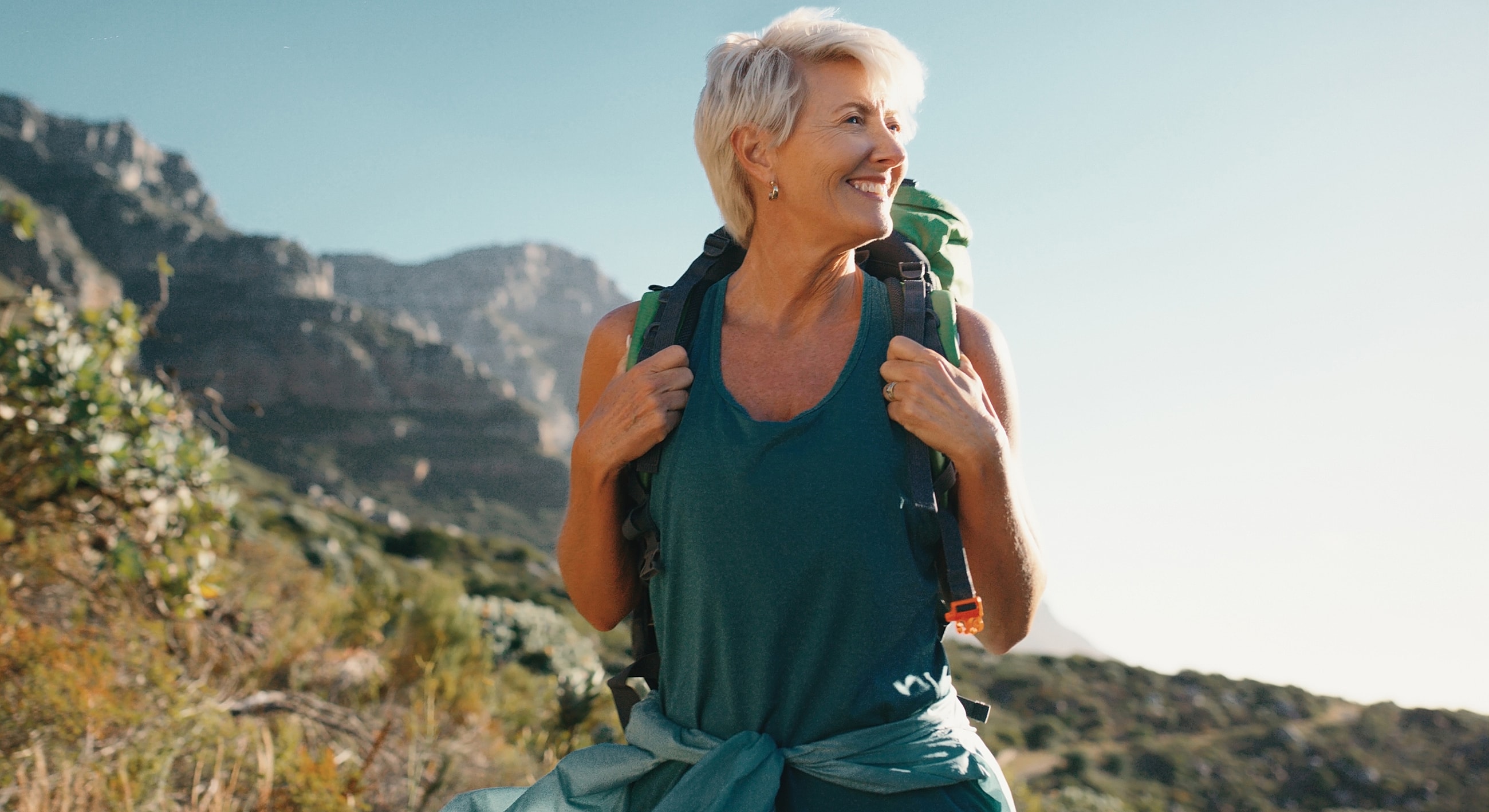 Smiling hiker enjoying a scenic mountain view.